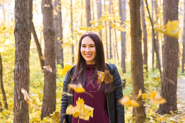 Młoda kobieta śmieszne rzucanie liści w parku jesień — Zdjęcie stockowe