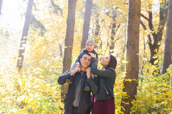 家族、秋には、人々 の概念 - 秋の日、ハグと笑顔で公園を歩いて若い家族 — ストック写真