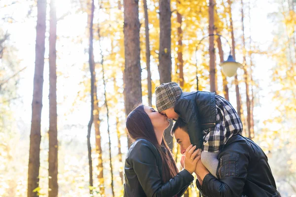 Föräldraskap, hösten och människor koncept - ung familj glad i höst park — Stockfoto