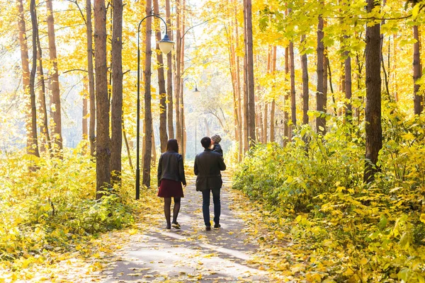 Wandelen in de herfst park, achteraanzicht herfst, de natuur en de familie concept - familie — Stockfoto