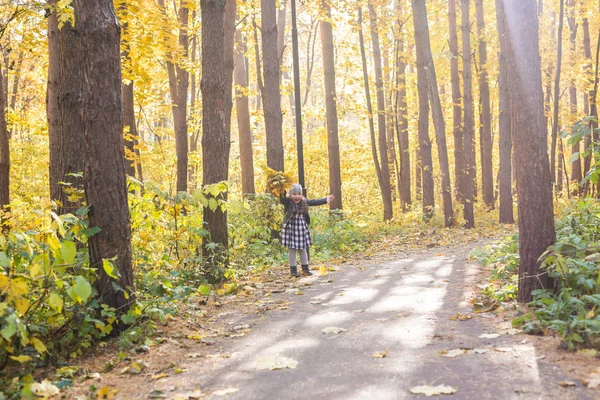 Kind, de natuur en de familie concept - gelukkig klein meisje lachen en spelen in het najaar op de natuur lopen buiten — Stockfoto