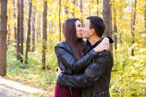 Kärlek, relation, familj och människor koncept - mannen som kysser hustrun i höst park — Stockfoto