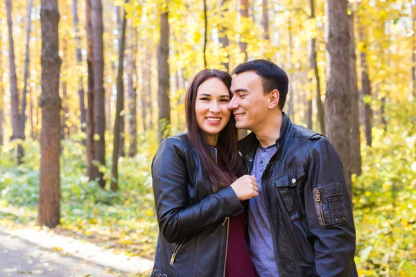 Amor, relación, familia y concepto de personas - pareja sonriente abrazándose en el parque de otoño — Foto de Stock