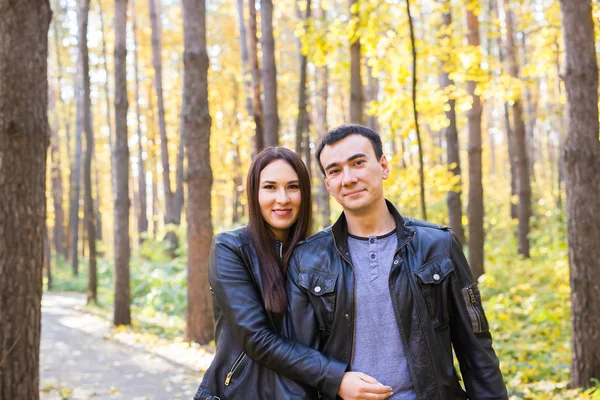 Любовь, отношения, семья и люди - улыбающаяся пара обнимается в осеннем парке — стоковое фото