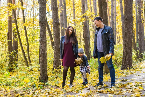 People, family and leisure concept - mixed race father and mother have fun in autumn park with their daughter — Stock Photo, Image
