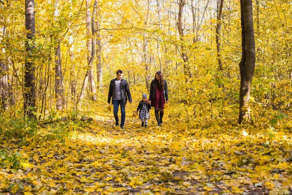 Familie, herfst, mensen concept - jonge gezin lopen in park op in herfstdag — Stockfoto