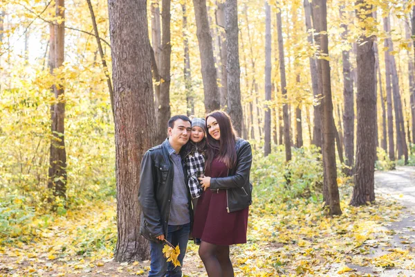 Concepto de personas, familia y ocio: diversión familiar de pie en el parque de otoño — Foto de Stock