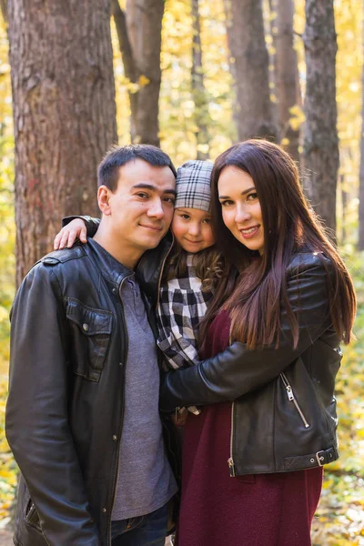 Familia, otoño, concepto de personas - familia joven de raza mixta caminando en el parque en el día de otoño — Foto de Stock