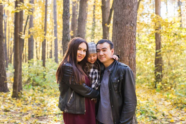 Concept d'enfants, de nature et de famille - Portrait de famille heureuse sur fond de parc d'automne — Photo