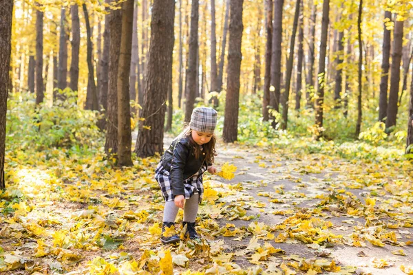 Παιδί, φύση και οικογένεια έννοια - ευτυχισμένη κοριτσάκι γελώντας και παίζοντας το φθινόπωρο σχετικά με τη φύση με τα πόδια σε εξωτερικούς χώρους — Φωτογραφία Αρχείου