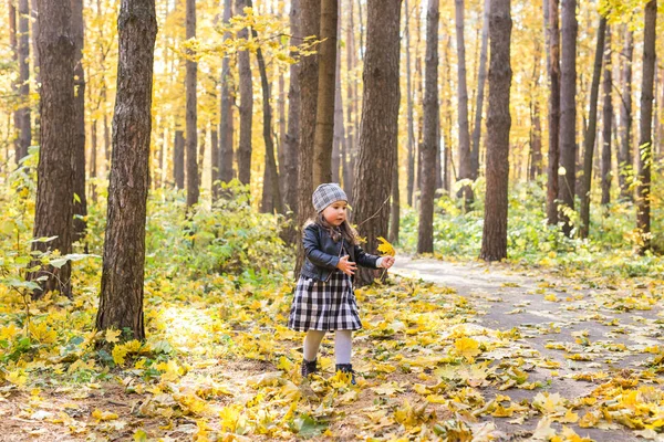 Παιδί, φύση και οικογένεια έννοια - ευτυχισμένη κοριτσάκι γελώντας και παίζοντας το φθινόπωρο σχετικά με τη φύση με τα πόδια σε εξωτερικούς χώρους — Φωτογραφία Αρχείου
