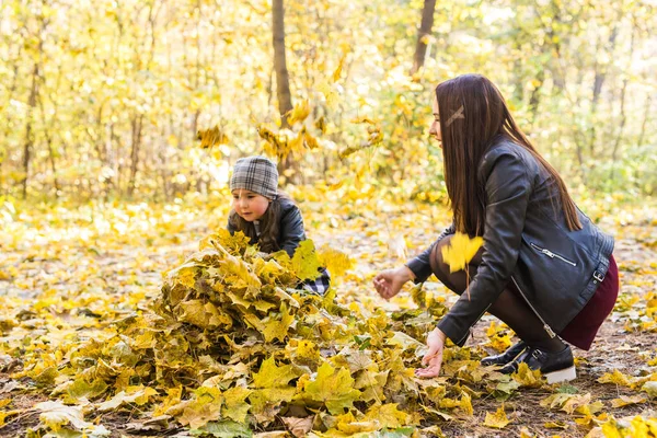 Mujer joven con hija pequeña pasar tiempo en la naturaleza de otoño —  Fotos de Stock