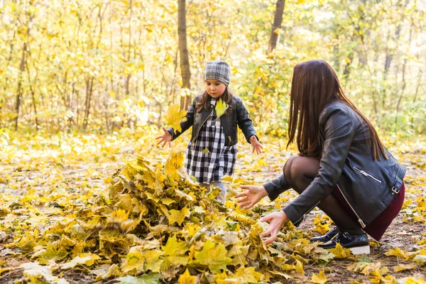 Concepto de familia feliz madre e hija pequeña jugando en la naturaleza de otoño —  Fotos de Stock