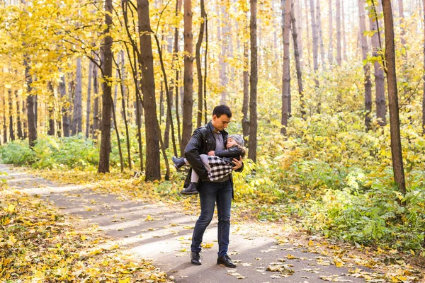 Familie, herfst, mensen concept - vader en dochter lopen in herfst park — Stockfoto