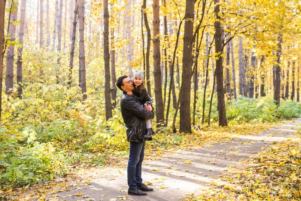 Vaderschap, kinderen en familie concept - vader houdt van zijn dochter in herfst park — Stockfoto