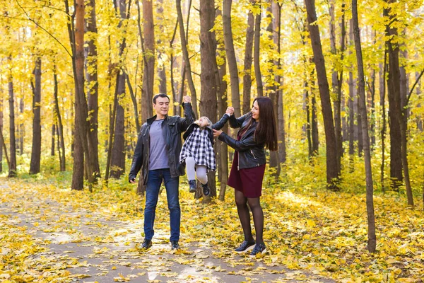 Семья, осень, люди - молодая семья гуляет в парке в осенний день — стоковое фото