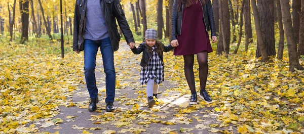 Oameni, familie și concept de agrement - familie cu o fiică tânără care merge în parcul de toamnă — Fotografie, imagine de stoc