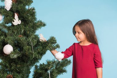 Noel, çocukluk ve insanlar kavramı - küçük kız Noel ağacı süsleme