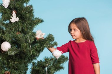 Noel, çocukluk ve insanlar kavramı - küçük kız Noel ağacı süsleme