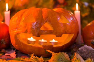 Cadılar Bayramı balkabağı fener kuru yapraklar ve mum