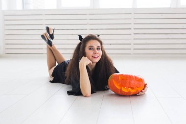 Cadılar Bayramı ve maskeli balo kavramı - güzel genç kadın ile Jack-o-fener kabak poz.