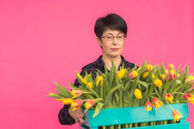 Lale pembe Studio kutu ile orta yaşlı beyaz kadın.