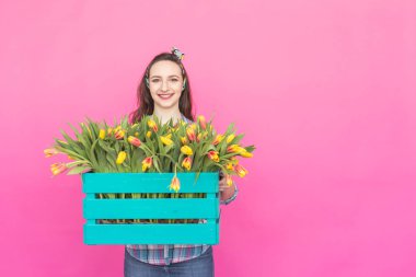 Mutlu güzel esmer beyaz kız lale kopya alanı ile pembe arka plan üzerinde büyük kutu ile