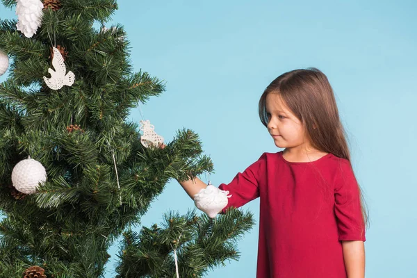 Boże Narodzenie, dzieciństwa i ludzi pojęcie - mała dziewczynka dekorowanie choinki — Zdjęcie stockowe