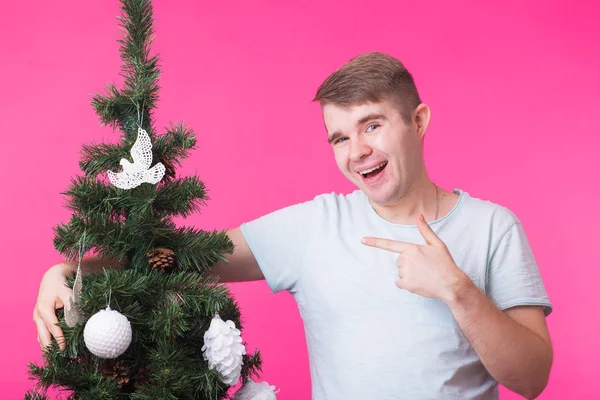 Concetto natalizio e festivo - Ritratto di uomo sorridente con albero di Natale su sfondo rosa — Foto Stock