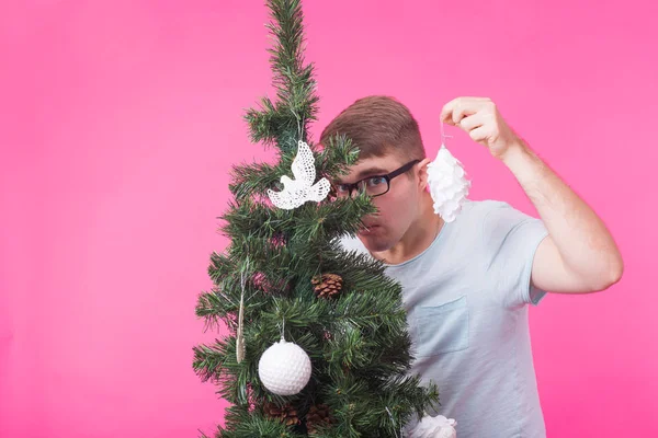 Boże Narodzenie i wakacje koncepcja - portret uśmiechający się człowieku z choinki na różowym tle — Zdjęcie stockowe