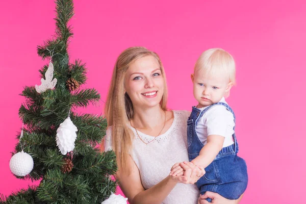 Concepto de Navidad y vacaciones - Retrato de mujer sonriente con su hija pequeña y árbol de Navidad — Foto de Stock