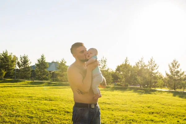 Buon padre che tiene in braccio il bambino sulla natura. Concetto di famiglia felice, giorno di padri e bambino . — Foto Stock