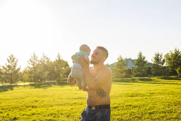 Buon padre che tiene in braccio il bambino, che lancia il bambino in aria. Concetto di famiglia felice, giorno di padri e bambino . — Foto Stock