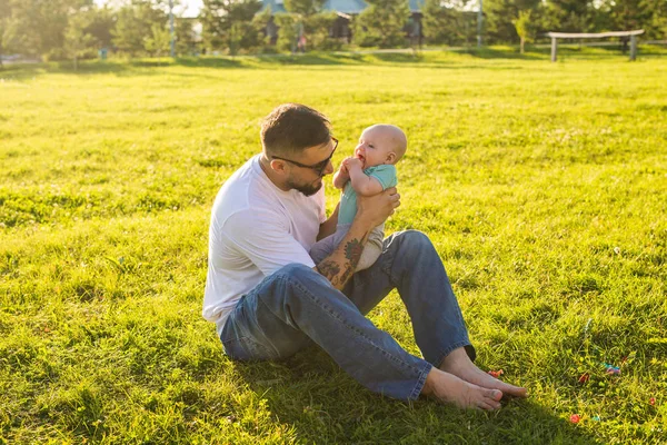 Buon padre che tiene in braccio il bambino sulla natura. Concetto di famiglia felice, giorno di padri e bambino . — Foto Stock