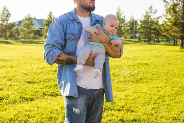 Pai feliz segurando bebê filho na natureza. Conceito de família feliz, dia dos pais e filho . — Fotografia de Stock