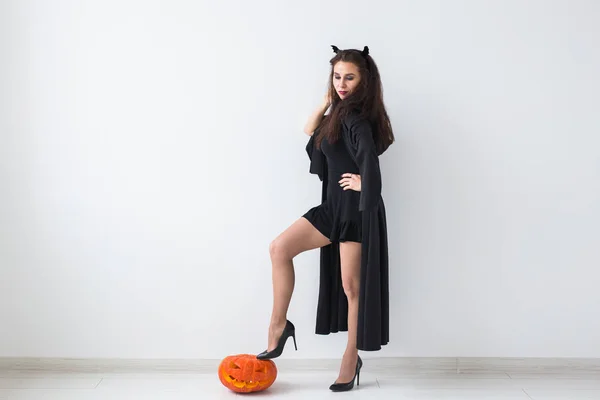 Halloween tök világos háttér-val másol hely felett egy elegáns barna nő portréja — Stock Fotó