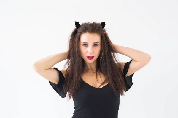 Halloween és helyettesítő koncepció - gyönyörű fiatal nő pózol a világos háttér — Stock Fotó