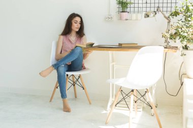 İnsanlar, eğitim ve iç kavramı - genç öğrenci kadın sandalyede oturan ve bir kitap okuma