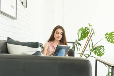 Teknolojileri, iletişim, kadın deri koltukta oturan ve dijital tablet kullanarak kavramı - genç insanlar