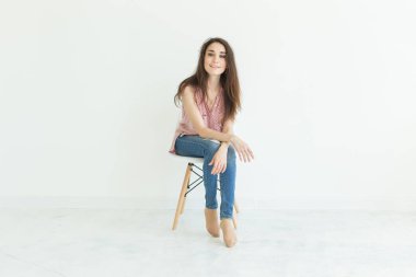 Beyaz arka plan kopya alanı ile sandalyede oturan genç bayan