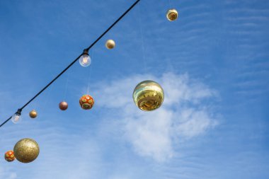 Mavi gökyüzüne karşı asılı Noel topları