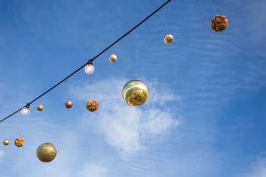 Mavi gökyüzüne karşı asılı Noel topları