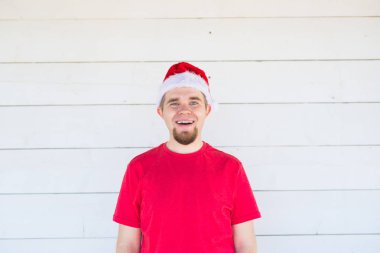 Noel, özel günler, insanlar kavramı - santa şapka ve beyaz arka plan üzerinde gülümseyen gömlek komik delikanlı