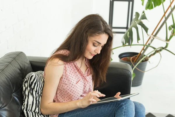 Kişi, çalışma ve teknoloji kavramı - tablet ile kanepede oturan rahat genç kadın