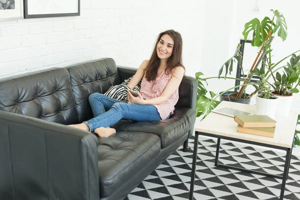 İnsanlar, eğlence ve teknoloji kavramı - Oda akıllı telefon kullanan genç kadın