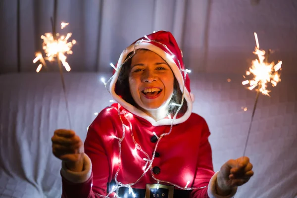 Ünnep, a karácsony és az emberek koncepció-fiatal boldog nő a Santa ruha csillagszórók — Stock Fotó
