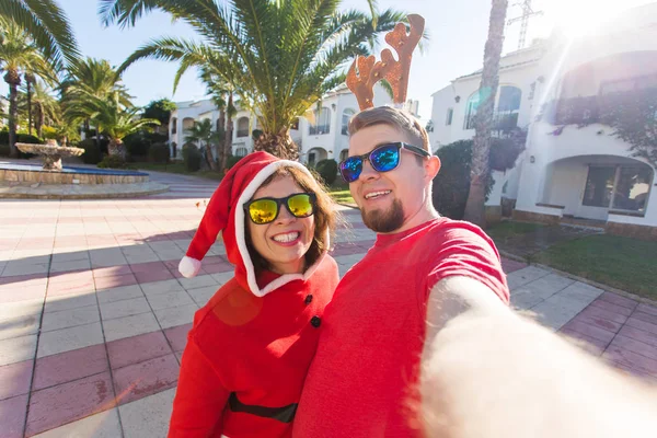 Noël, humour, concept de personnes - Joyeux couple de Noël s'amuser près des paumes — Photo