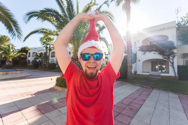 Noel, özel günler, mizah, insanlar kavramı - adam kafasını dan Noel şapka çıkarmak