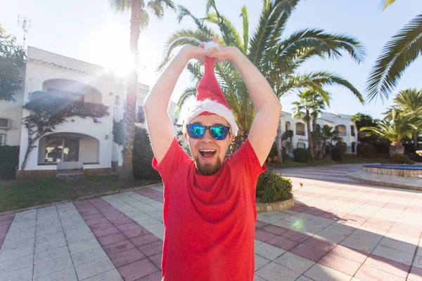 Bayram, yılbaşı ve insanlar kavramı - santa şapka sürpriz komik yakışıklı adam