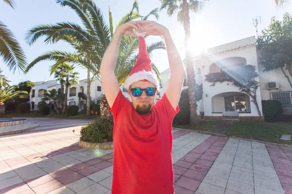 Bayram, yılbaşı ve insanlar kavramı - santa şapka sürpriz komik yakışıklı adam